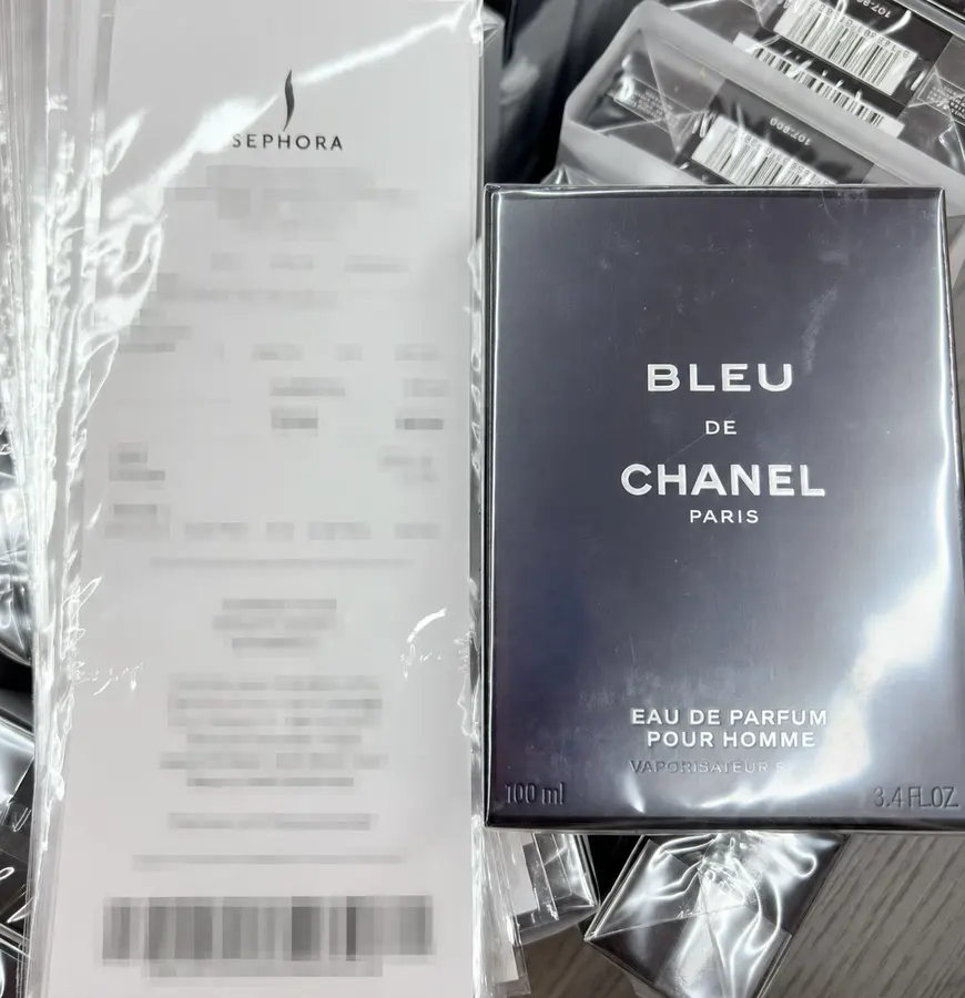 Redacted retail purchase record shown beside Bleu de Chanel packaging